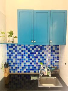 - une cuisine avec des placards bleus et un évier dans l'établissement Alba house 53 Hang Buom, à Hanoï