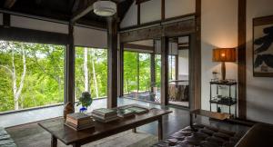 a living room with a couch and a table with books at SHIGUCHI in Kutchan