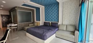 a bedroom with a purple bed and a couch at Condo Express View Talay 6 in Pattaya Central