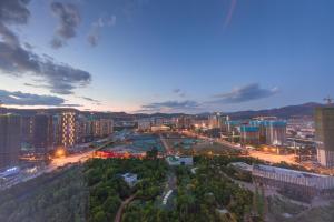 昆明市にあるGongxili - Yuejian Hotelの建物や道路のある夜の街のスカイライン