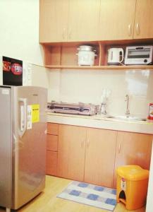 a kitchen with a stainless steel refrigerator and a sink at Aeon Palace Apartment in Manila