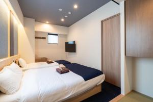 a hotel room with a bed and a tv at stayme THE HOTEL Ueno in Tokyo