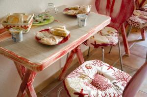 a wooden table with plates of food and chairs at B&B Nonna Sini in Castelsardo