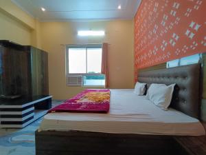 a bedroom with a bed with a red headboard and a window at Hotel O Home HR Homes in Ayodhya +24 photos