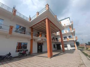 a large white building with orange columns and a balcony at Hotel O Home HR Homes in Ayodhya