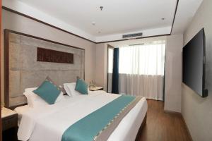 Wanzai的住宿－嘉华大酒店(宜春万载古城店)，卧室配有一张白色大床和电视。