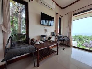 una camera con tavolo, sedia e finestra di Seabreeze @ Koh Mak a Ko Mak