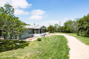 a small white house with a road leading to it at Hadley's House - A Country 3 Bdrm with Screened-In Porch in New Braunfels