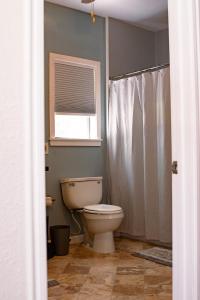 a bathroom with a toilet and a window at Hadley's House - A Country 3 Bdrm with Screened-In Porch in New Braunfels