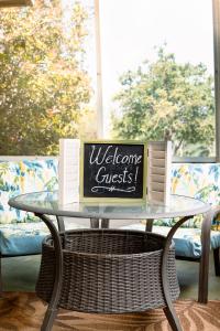 un tavolo di vetro con un cartello di benvenuto per gli ospiti di Hadley's House - A Country 3 Bdrm with Screened-In Porch a New Braunfels
