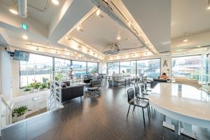 a large room with tables and chairs and windows at Haedam House in Jeju