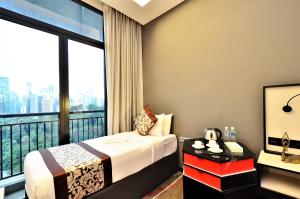 a hotel room with a bed and a large window at Maison 101 Dang Wangi in Kuala Lumpur