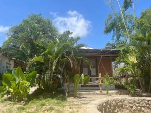 una casa con palmeras delante en KUA Cabañas, en Palomino