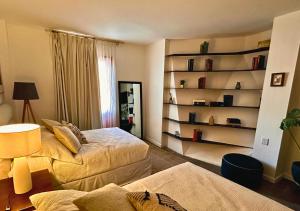 a room with two beds and a book shelf at The Isabel Hotel in Sombrerete