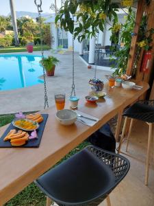 a wooden table with food on it next to a pool at CHAMBRE NAMIBIE, villa belle vue 