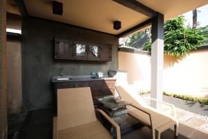 a kitchen with a sink and a table and chairs at Gino Feruci Villa Ubud by KAGUM Hotels in Ubud