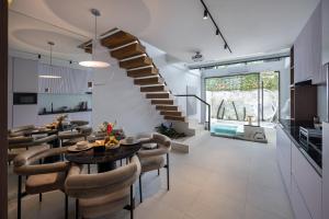 ein Esszimmer und ein Wohnzimmer mit einer Wendeltreppe in der Unterkunft Alex Villas Complex N2 in Canggu