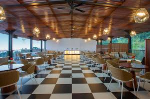 um restaurante com piso em xadrez, mesas e cadeiras em Surya Hotel & Cottages Prigen em Tretes