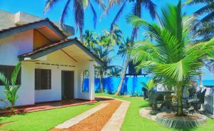 una casa con palmeras frente al océano en Dinuli home stay, en Ahungalla