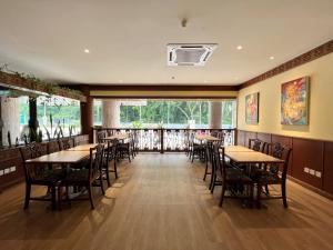 un restaurante con mesas y sillas y una gran ventana en The Borneo Hotel, en Kuching