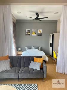 ein Wohnzimmer mit einem Sofa und einem Bett in der Unterkunft Mahkota Valley (Rumah Hotel) in Kuantan