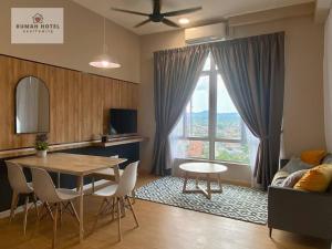 ein Wohnzimmer mit einem Tisch, Stühlen und einem Fenster in der Unterkunft Mahkota Valley (Rumah Hotel) in Kuantan