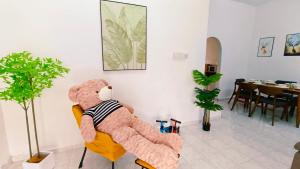 ein großer Teddybär auf einem Stuhl in der Unterkunft 322 Kulai Tmn Bersatu 4BR 10pax Smart Tv near JPO in Kulai