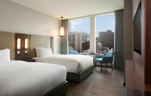 a hotel room with two beds and a view of a city at Courtyard by Marriott Seoul Namdaemun in Seoul