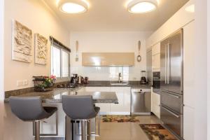 a kitchen with a counter and two stools in it at Beautiful Apts w/ Large Balcony & Parking by Sea N' Rent in Tel Aviv