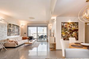 a living room with a white couch and a table at Beautiful Apts w/ Large Balcony & Parking by Sea N' Rent in Tel Aviv