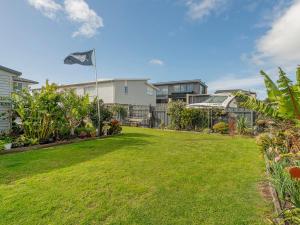 a yard with a kite flying in the sky at Beside the sea, park up and relax - Just 20 steps to the beach - Wi-Fi & Linen in Whitianga