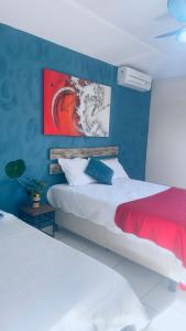 ein Schlafzimmer mit 2 Betten und einem Wandgemälde in der Unterkunft Do Maraja in Búzios