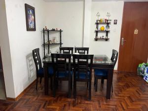 ein Esszimmer mit einem schwarzen Tisch und Stühlen in der Unterkunft Depa en san Miguel in Lima