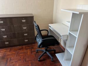 een kantoor met een zwarte stoel en een bureau bij Depa en san Miguel in Lima