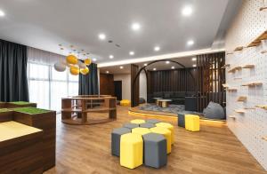 una hall con sgabelli gialli e blu in una stanza di Family-Friendly 3-Bedroom Condo at IOI Resort City a Kampong Abu Bakar