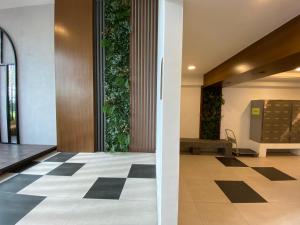 un corridoio con pavimento a scacchi in un edificio di Family-Friendly 3-Bedroom Condo at IOI Resort City a Kampong Abu Bakar