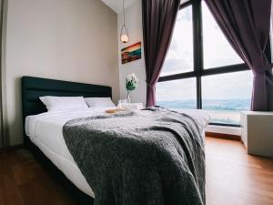 a bedroom with a bed and a large window at Family-Friendly 3-Bedroom Condo at IOI Resort City in Kampong Abu Bakar