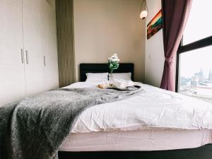 a bedroom with a bed with a vase of flowers on it at Family-Friendly 3-Bedroom Condo at IOI Resort City in Kampong Abu Bakar