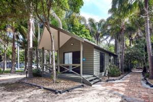 une petite cabine au milieu des palmiers dans l'établissement NRMA Murramarang Beachfront Holiday Resort, à Durras