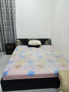 a bed with a blue and yellow blanket on it at Master Bedroom in Ajman 