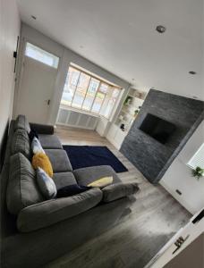 a living room with a gray couch in a room at Cosy Worsley Home with a Garden Bar! in Manchester