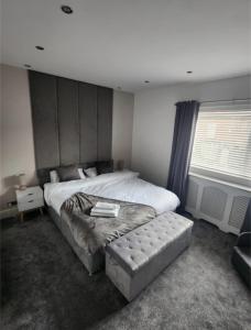 a bedroom with a bed and a chair and a window at Cosy Worsley Home with a Garden Bar! in Manchester