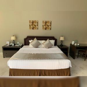 a bedroom with a large bed with two tables at Arainn Bed & Breakfast Tretes Prigen by ecommerceloka in Prigen