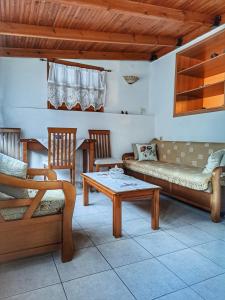 a living room with a couch and a table and chairs at Panthea Cottage in Stavroupoli