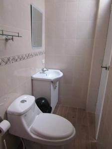 a bathroom with a white toilet and a sink at Casa de Playa en Colan Casa Merino. in Paita