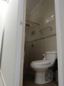 a bathroom with a white toilet and a shower at Casa de Playa en Colan Casa Merino. in Paita