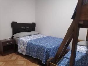 um pequeno quarto com uma cama e uma mesa de cabeceira em Casa de Playa en Colan Casa Merino. em Paita