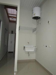 a bathroom with a sink and a light on the wall at Casa de Playa en Colan Casa Merino. in Paita
