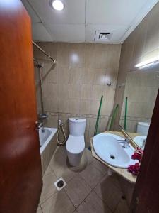 a bathroom with a toilet and a sink at Master Bedroom in Ajman 