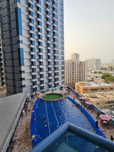 a large swimming pool in front of a large building at Master Bedroom in Ajman 